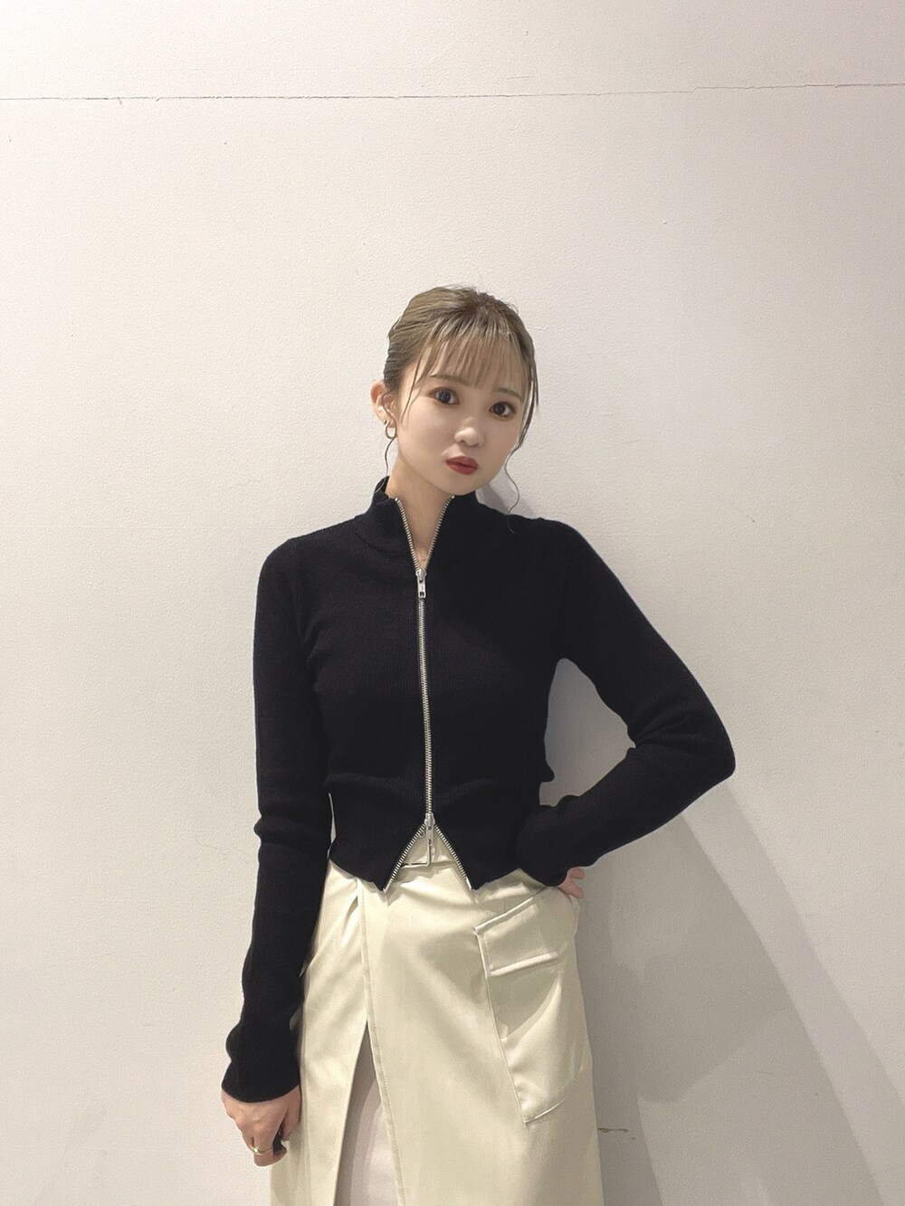 ホワイト系のスカート、ブラック系のニット/セーターを着用したレディースの秋コーディネートの2枚目の写真