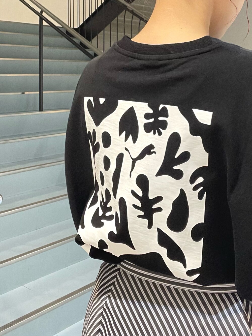 ブラック系のショルダーバッグ、ブラック系のTシャツ/カットソー、ブラック系のサンダルを着用したレディースの春コーディネートの4枚目の写真