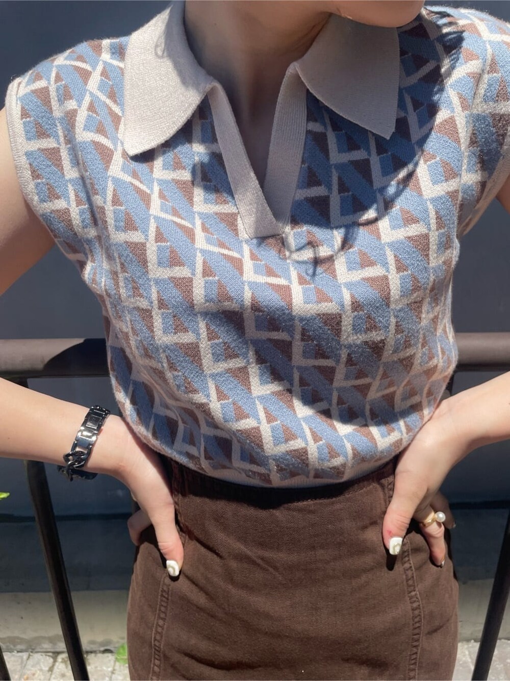 ホワイト系のショルダーバッグ、ブラウン系のブルゾン、ブラウン系のスカートを着用したレディースの夏コーディネートの4枚目の写真