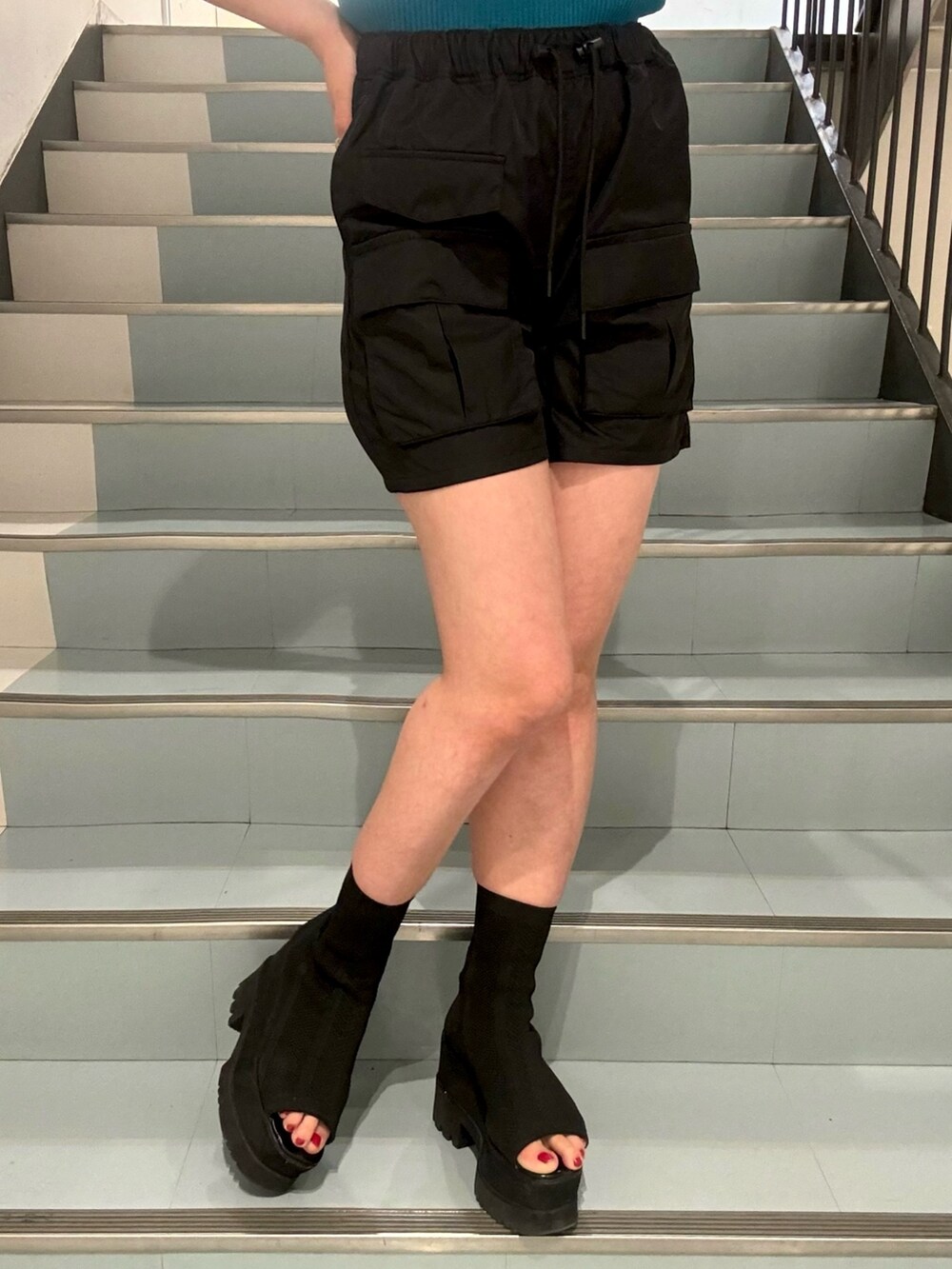 ピンク系のシャツ/ブラウス、ブルー系のニット/セーター、ブラック系のカーゴパンツを着用したレディースの春コーディネートの6枚目の写真