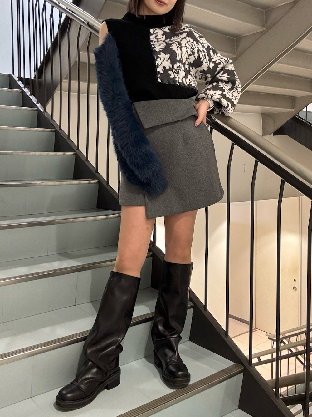 グレー系のスカート、ブラック系のブルゾン、ブラック系のニット/セーターを着用したレディースの冬コーディネートの6枚目の写真