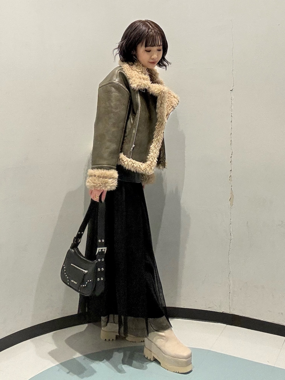 ホワイト系のニット/セーター、ブラック系のスカート、ホワイト系のブーツを着用したレディースの冬コーディネートの2枚目の写真