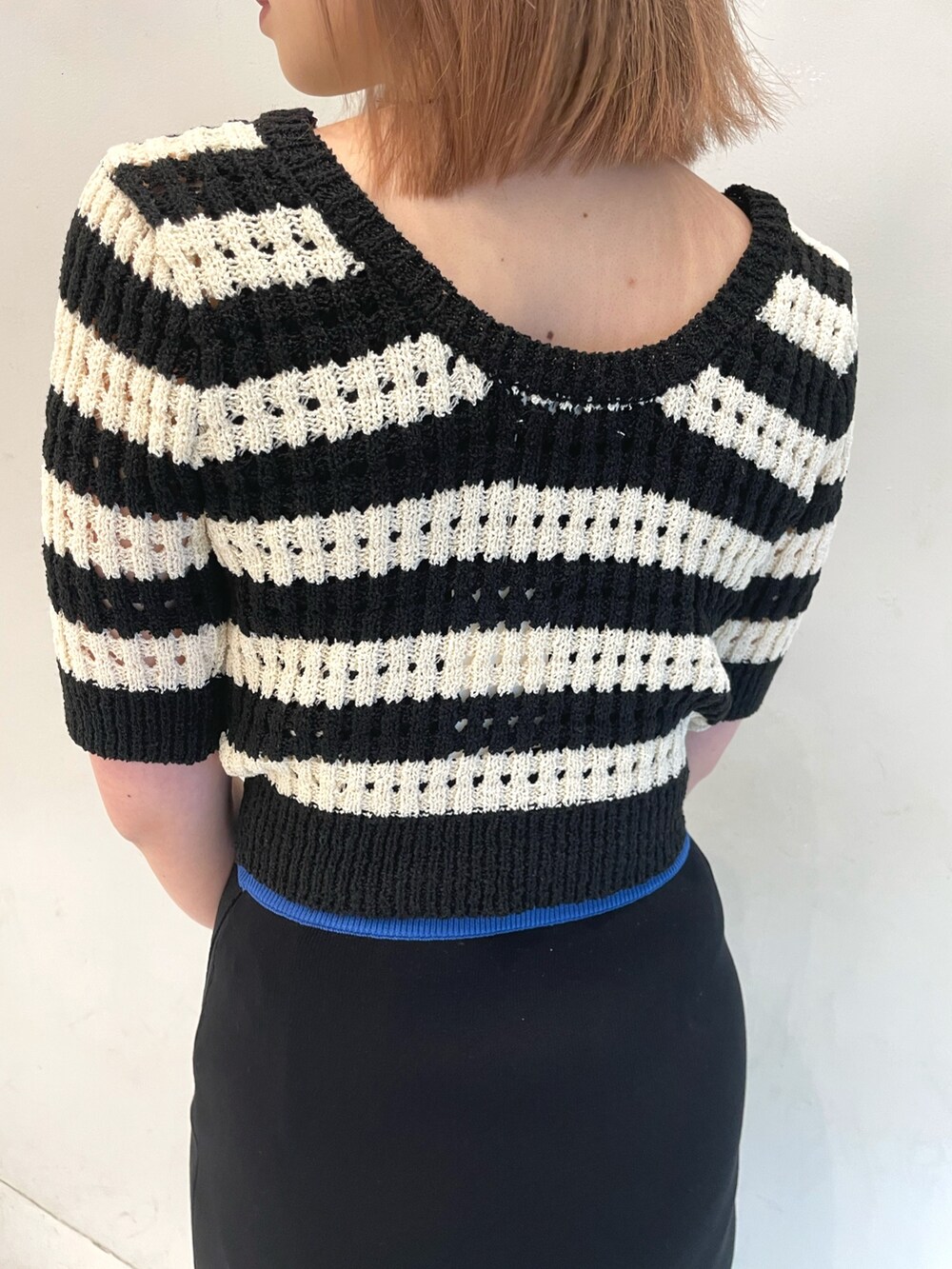 ブルー系のニット/セーター、ブラック系のサンダルを着用したレディースの春コーディネートの5枚目の写真