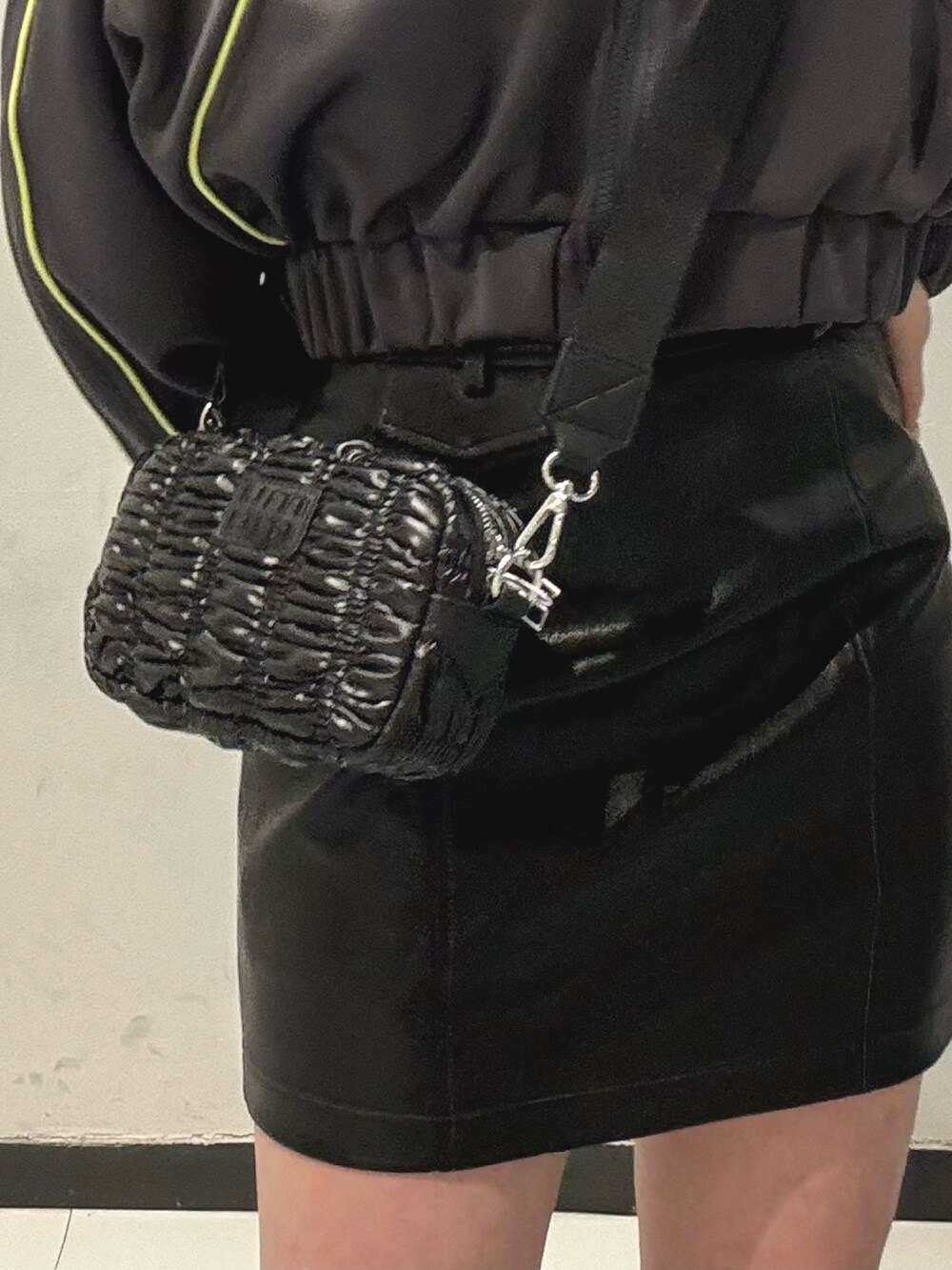 ブラック系のブーツ、グレー系のブルゾン、ブラック系のスカートを着用したレディースの春コーディネートの7枚目の写真