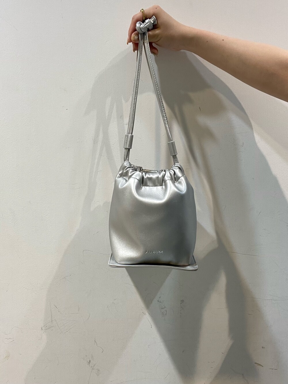 ホワイト系のサンダル、グレー系のスラックス、グレー系のテーラードジャケットを着用したレディースの春コーディネートの6枚目の写真