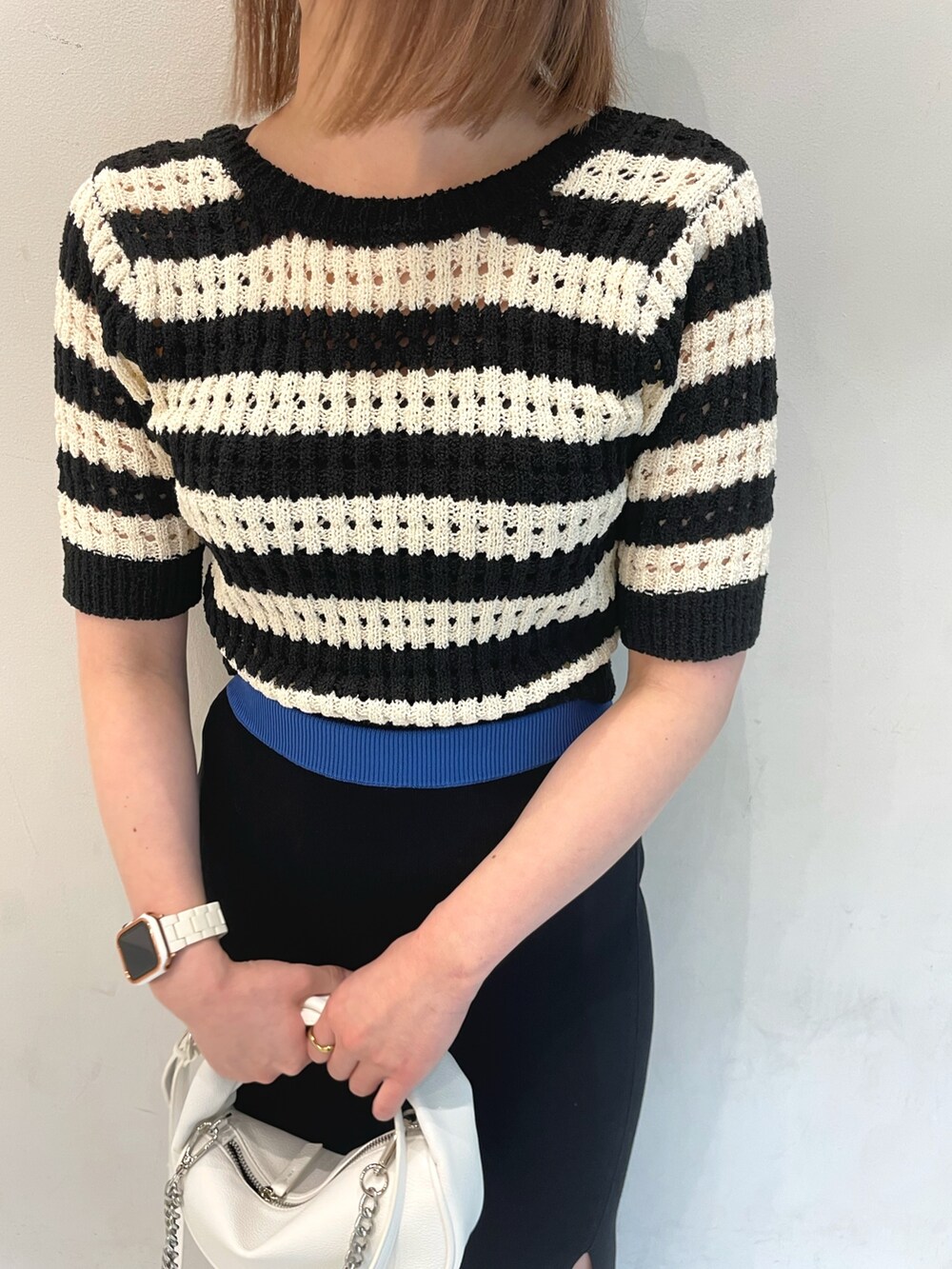 ブルー系のニット/セーター、ブラック系のサンダルを着用したレディースの春コーディネートの4枚目の写真