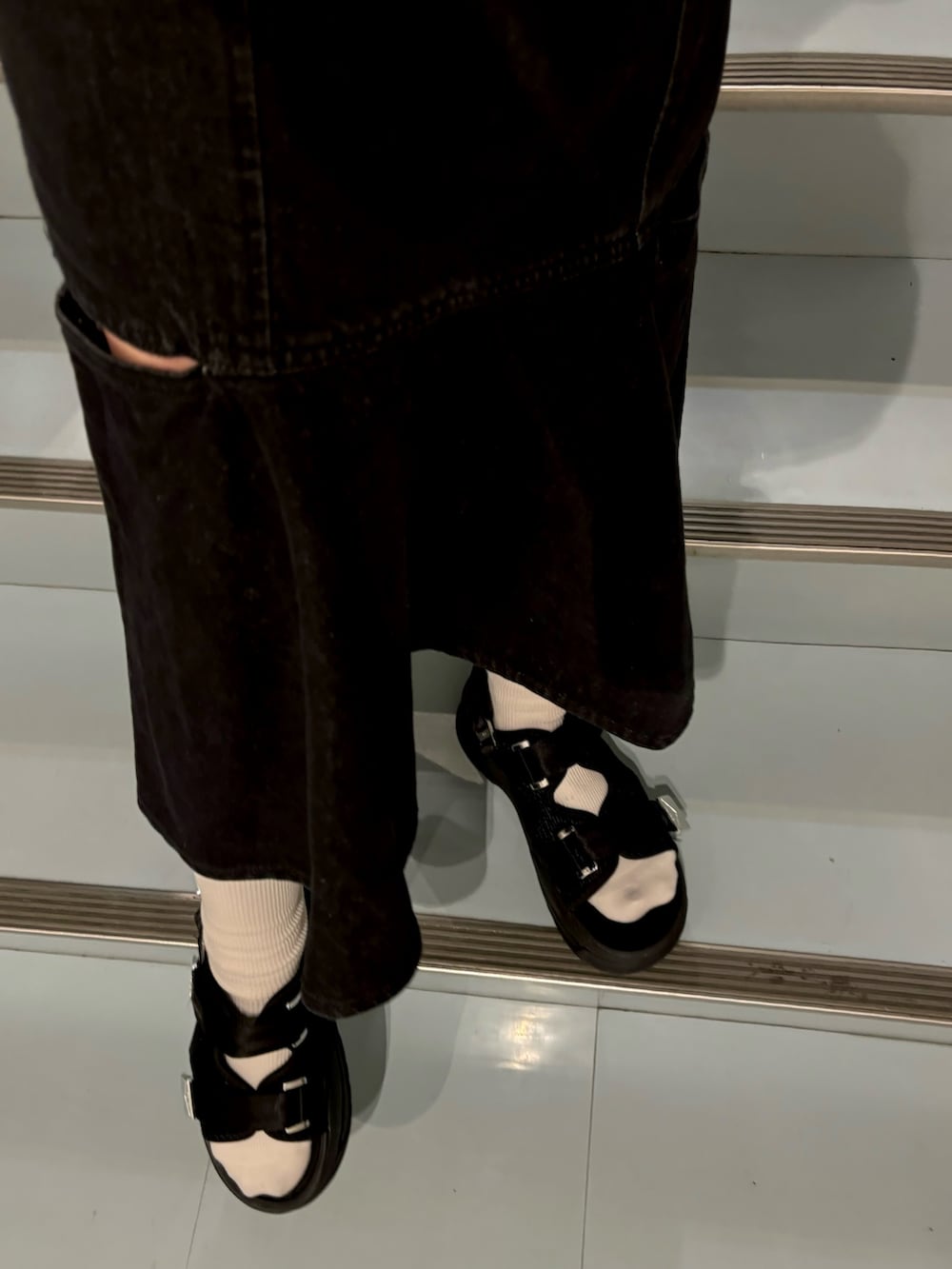 ブラック系のワンピース、ブラック系のサンダル、ホワイト系のTシャツ/カットソーを着用したレディースの夏コーディネートの5枚目の写真