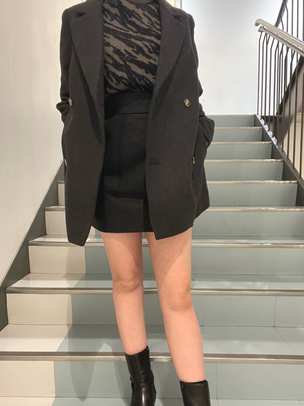 グレー系のテーラードジャケット、グレー系のニット/セーター、グレー系のスカートを着用したレディースの秋コーディネートの5枚目の写真