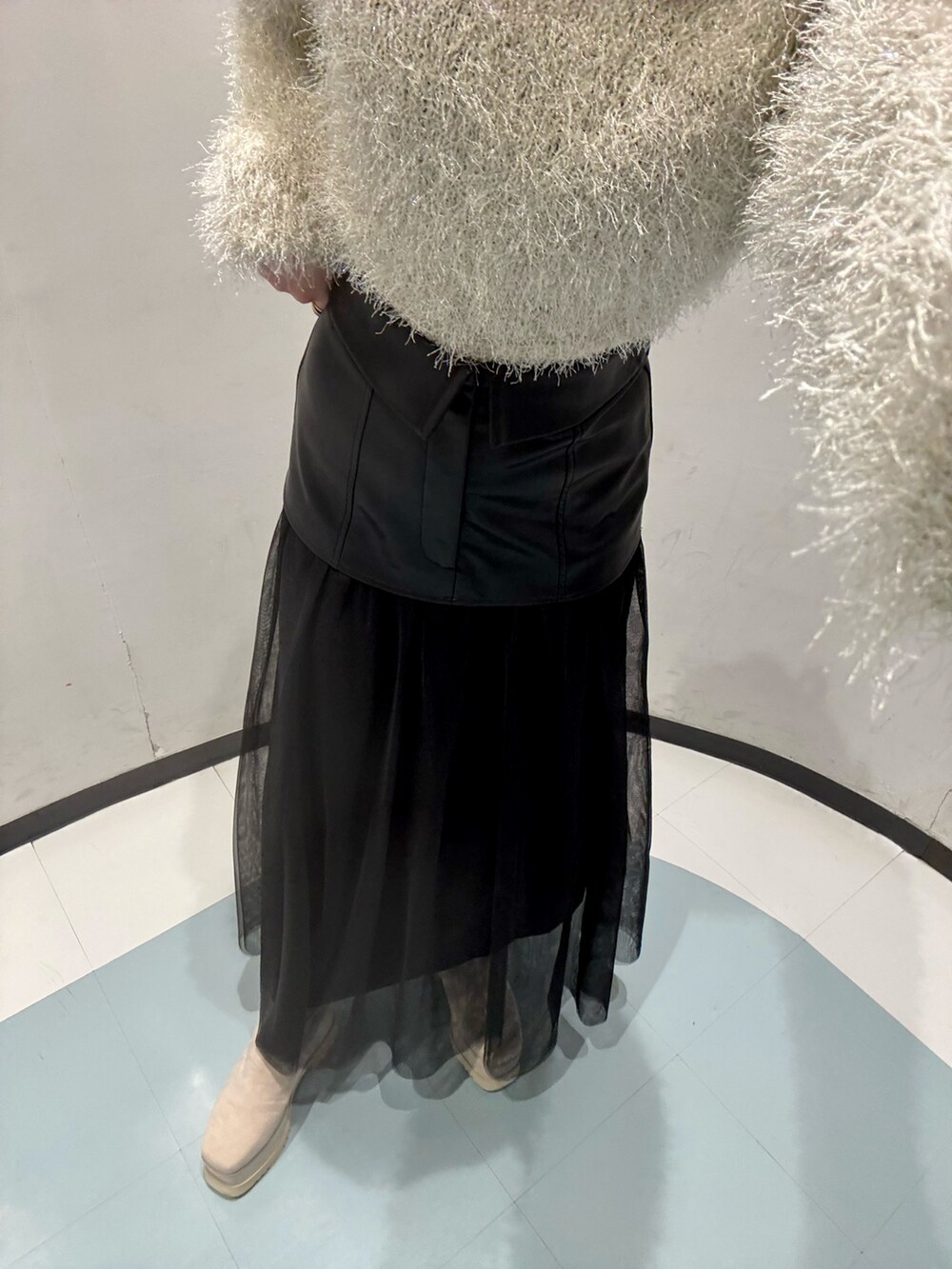 ホワイト系のニット/セーター、ブラック系のスカート、ホワイト系のブーツを着用したレディースの冬コーディネートの5枚目の写真