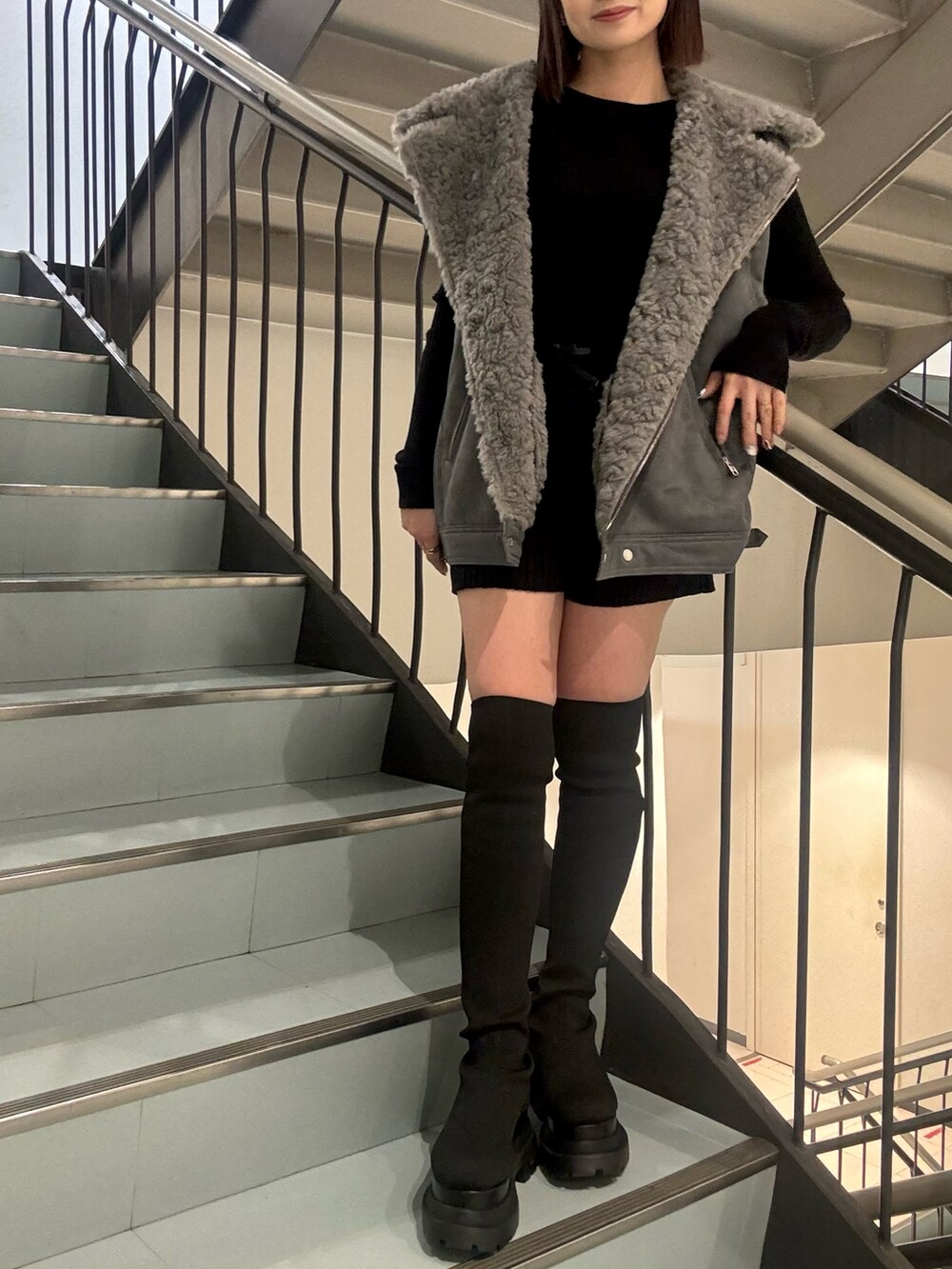 ブラック系のニット/セーター、ブラック系のその他パンツ、グレー系のムートンコートを着用したレディースの秋コーディネートの5枚目の写真