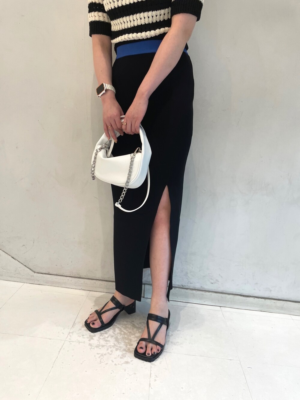 ブルー系のニット/セーター、ブラック系のサンダルを着用したレディースの春コーディネートの6枚目の写真