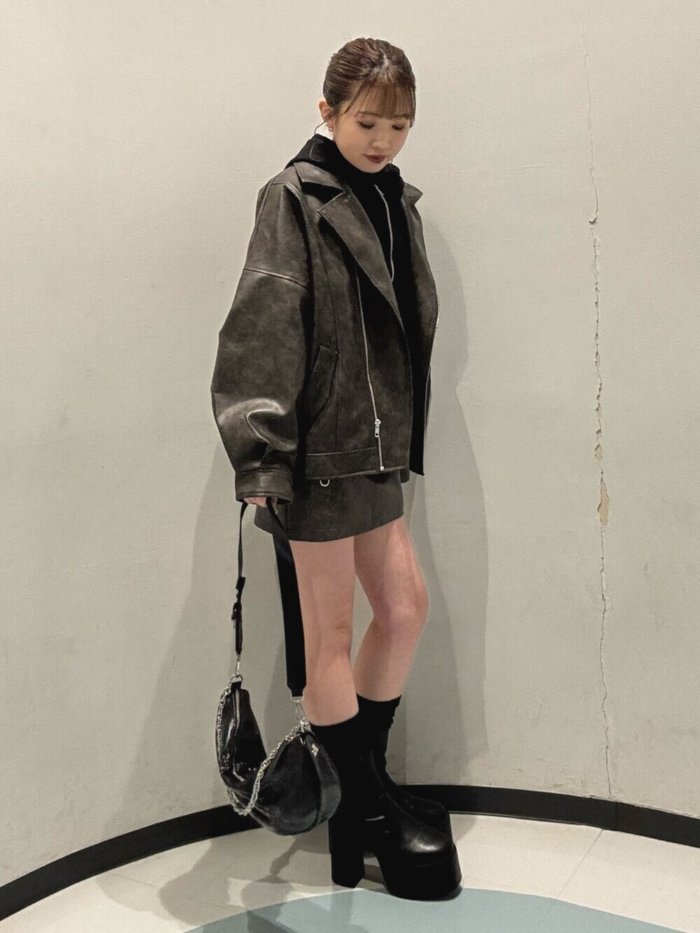 ブラック系のブーツ、ブラック系のパーカー、ブラウン系のブルゾンを着用したレディースの冬コーディネートの2枚目の写真