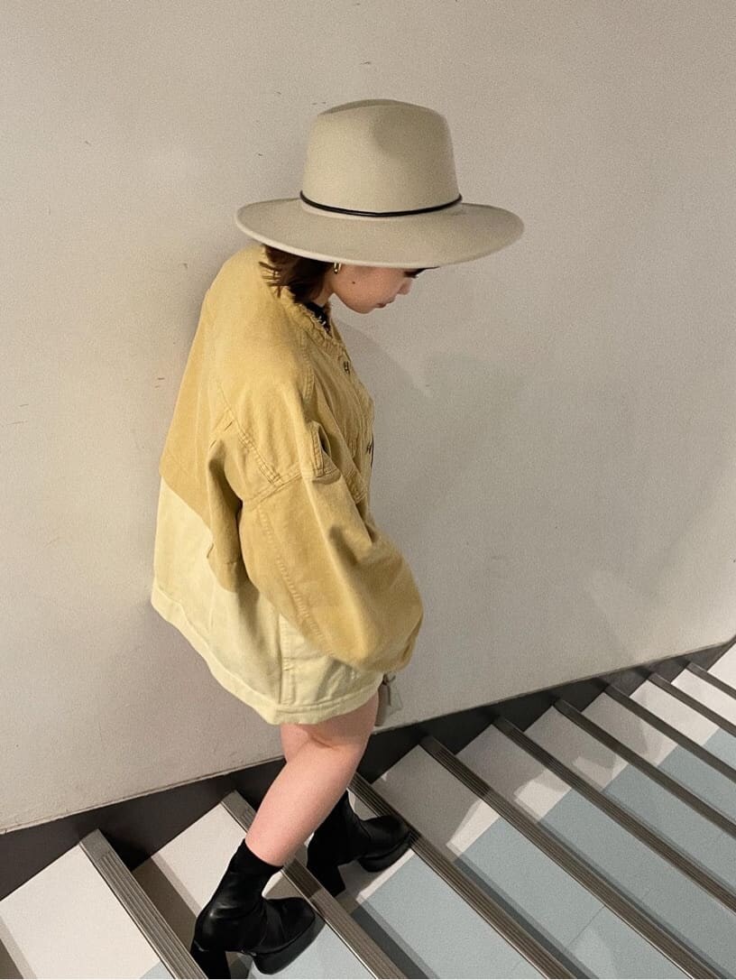 ホワイト系のハンドバッグ、イエロー系のデニムジャケット、イエロー系のスカートを着用したレディースの冬コーディネートの3枚目の写真