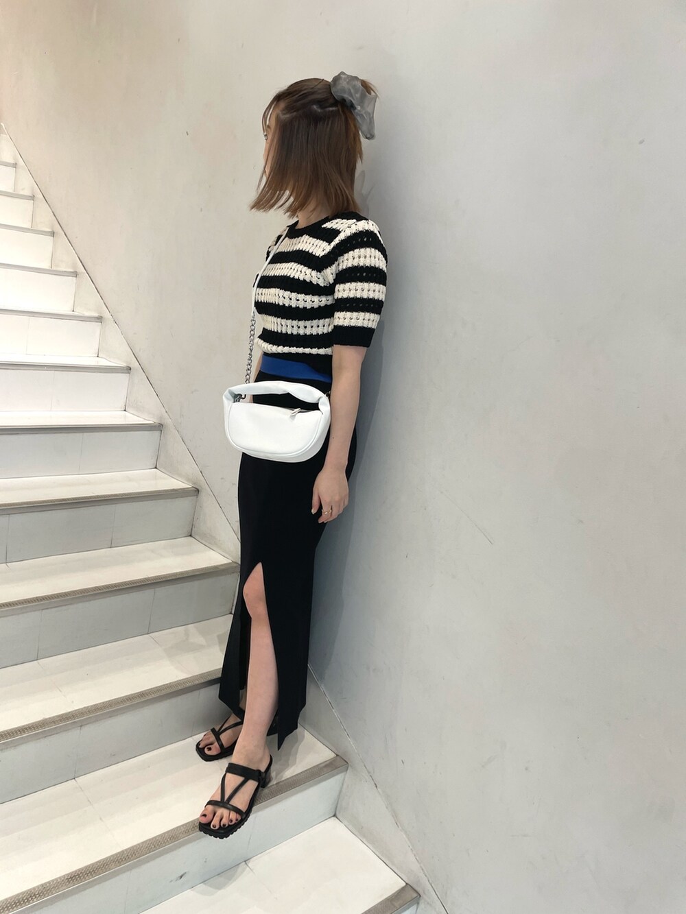 ブルー系のニット/セーター、ブラック系のサンダルを着用したレディースの春コーディネートの2枚目の写真