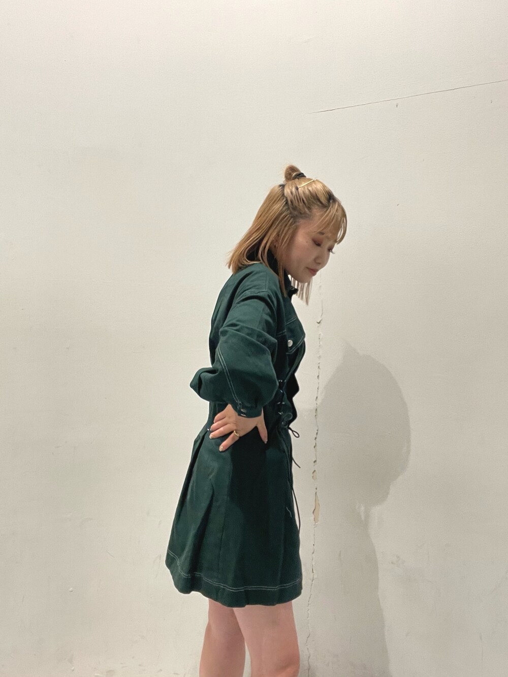 ホワイト系のショルダーバッグ、グリーン系のワンピースを着用したレディースの秋コーディネートの4枚目の写真