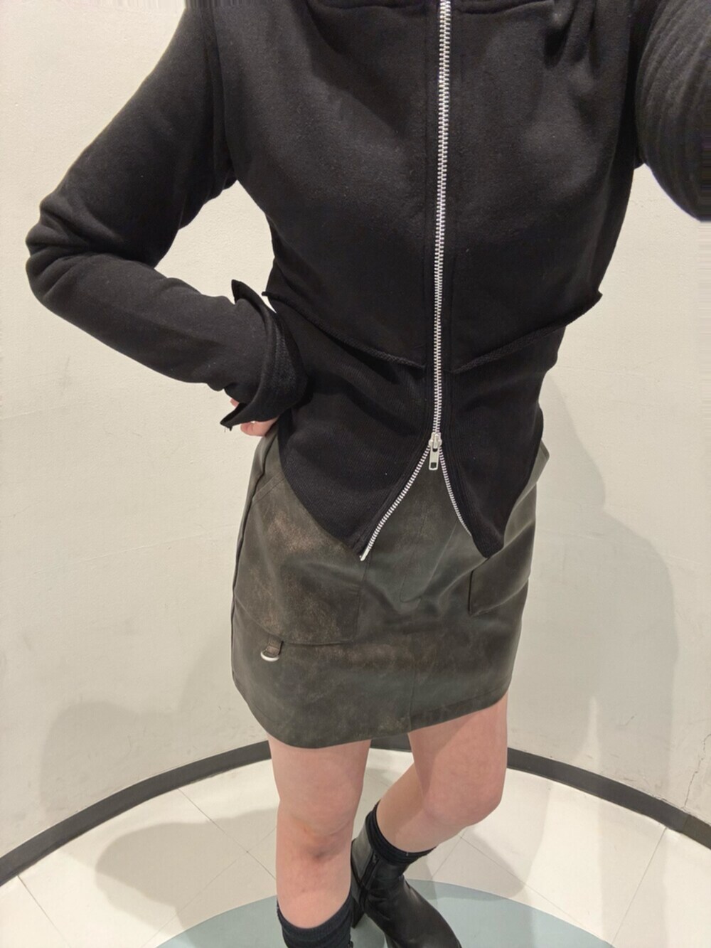 ブラック系のブーツ、ブラック系のパーカー、ブラウン系のブルゾンを着用したレディースの冬コーディネートの4枚目の写真