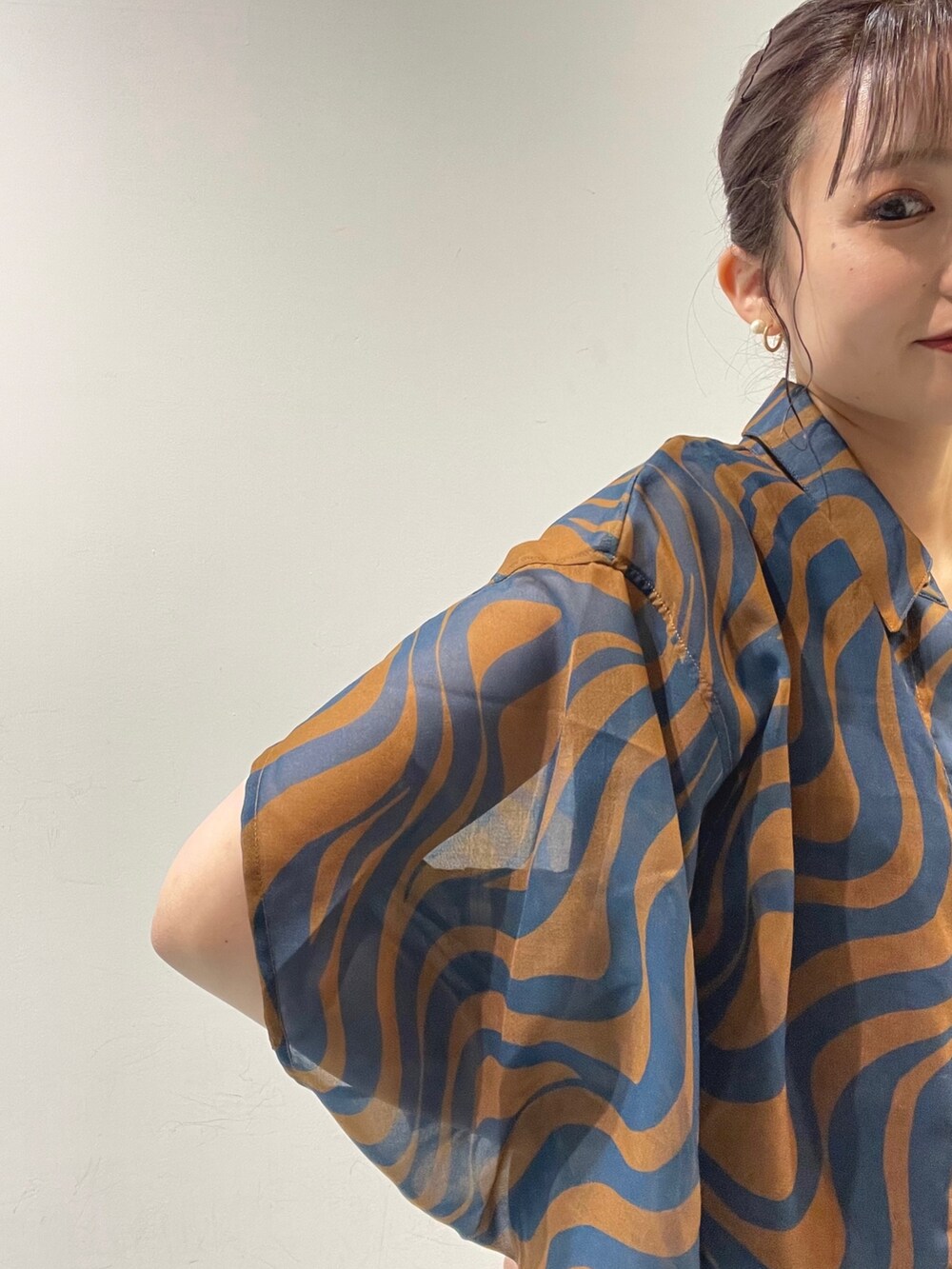 ブルー系のシャツ/ブラウス、ホワイト系のハンドバッグ、ブラック系のサンダルを着用したレディースの夏コーディネートの4枚目の写真
