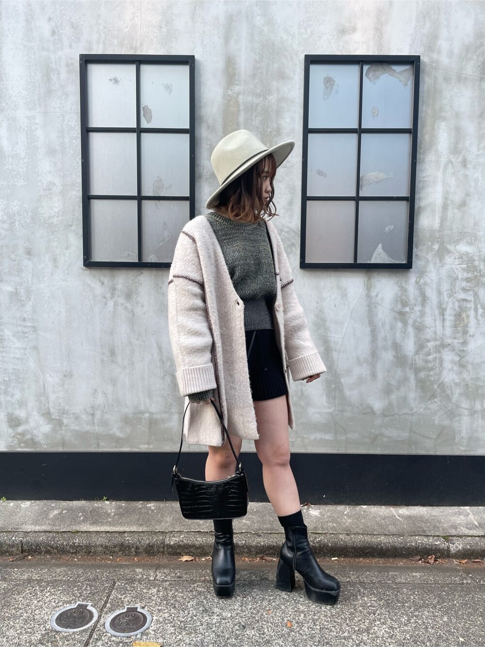 ホワイト系のカーディガン/ボレロ、ホワイト系のハンドバッグ、ブラック系のその他パンツを着用したレディースの冬コーディネートの5枚目の写真