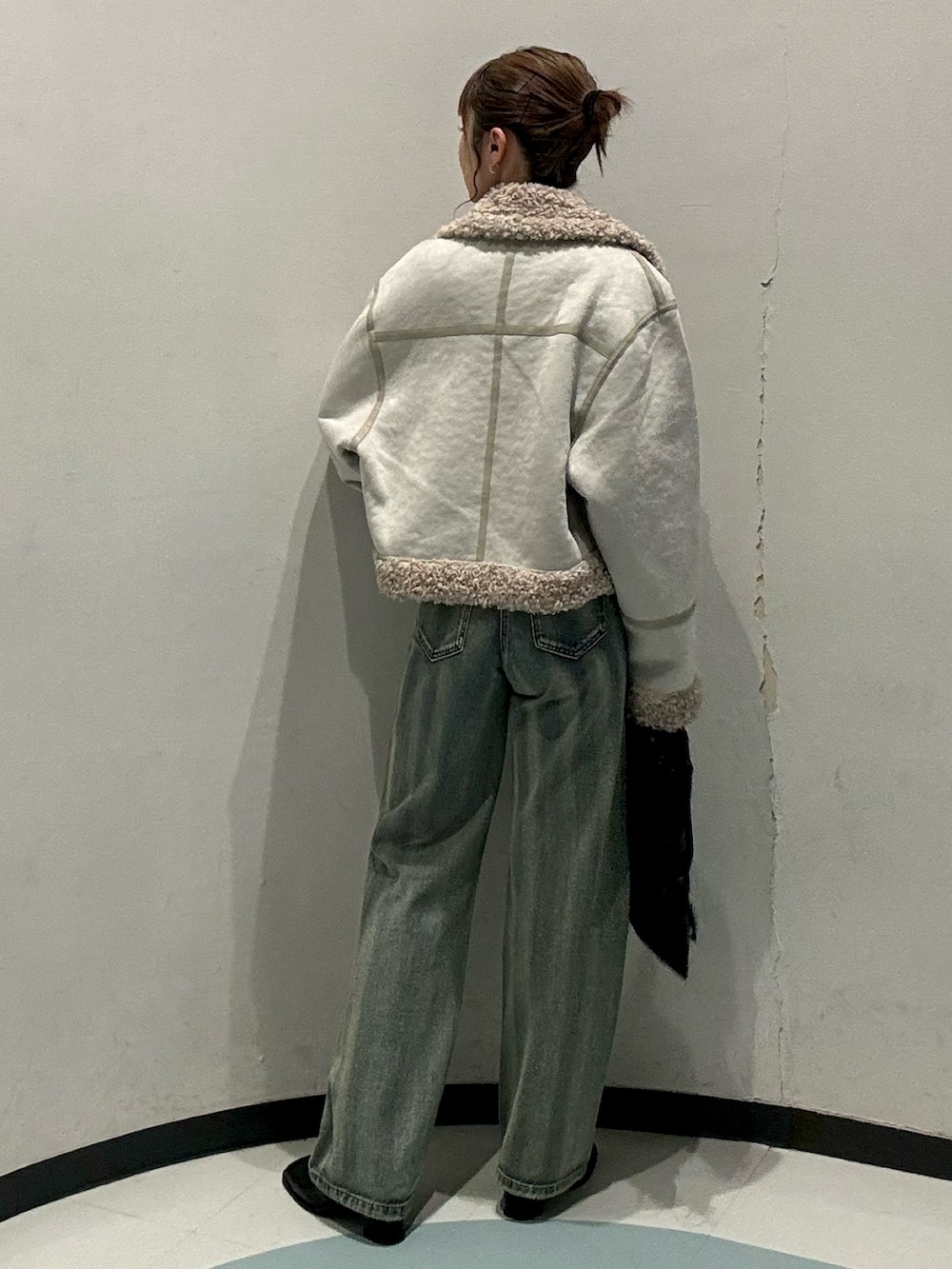 ブラック系のトートバッグ、ホワイト系のムートンコート、レッド系のニット/セーターを着用したレディースの秋コーディネートの3枚目の写真