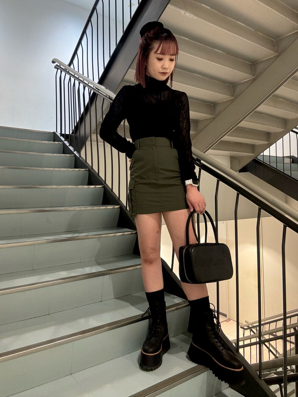 ブラック系のニット/セーター、ホワイト系のベスト、グリーン系のスカートを着用したレディースの秋コーディネートの6枚目の写真