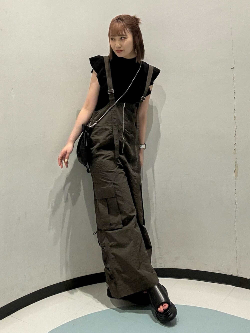 グレー系のつなぎ/オールインワン、ブラック系のニット/セーター、ブラック系のショルダーバッグを着用したレディースの夏コーディネートの2枚目の写真
