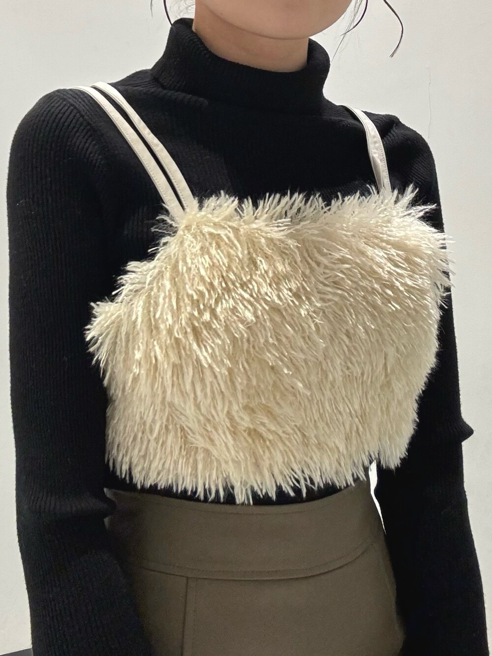 ブラック系のブーツ、ブラウン系のスカート、ブラック系のニット/セーターを着用したレディースの冬コーディネートの2枚目の写真