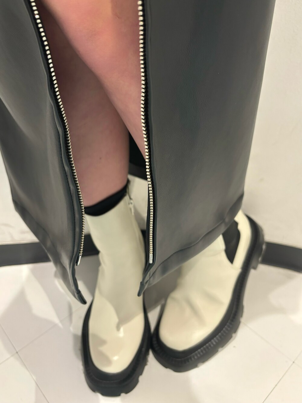 ホワイト系のブーツ、ブラック系のスカート、ブルー系のニット/セーターを着用したレディースの冬コーディネートの7枚目の写真