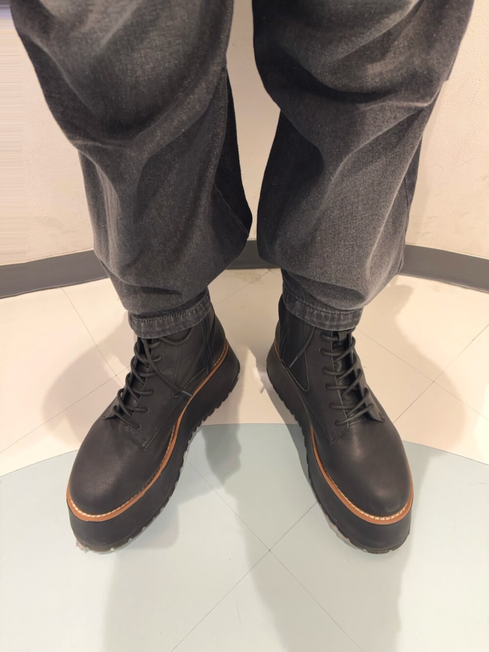 ブラック系のデニムパンツ、ブラック系のブーツ、ホワイト系のニット/セーターを着用したレディースの冬コーディネートの6枚目の写真