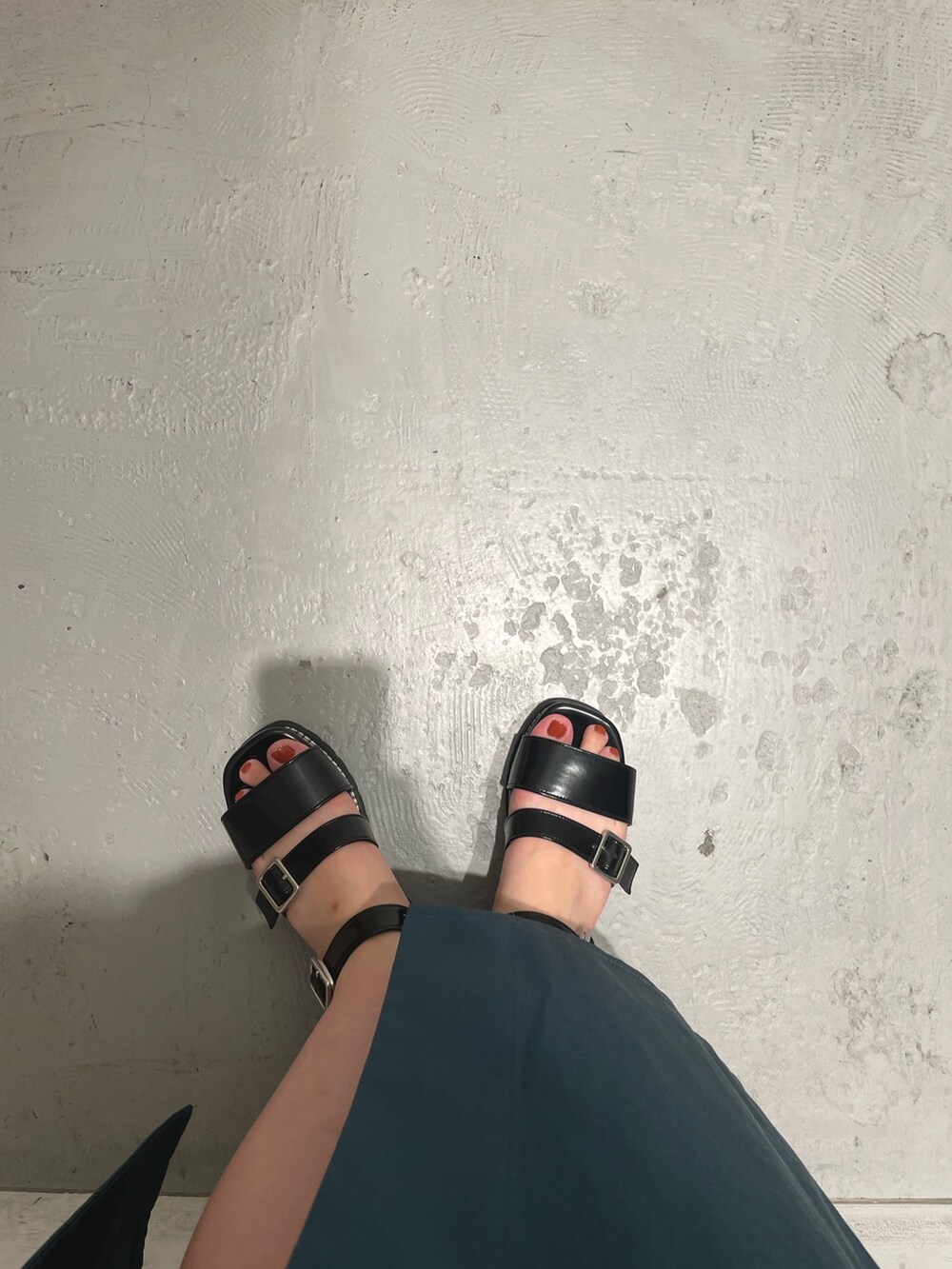 ブラック系のハンドバッグ、ブルー系のスカート、ブラック系のシャツ/ブラウスを着用したレディースの夏コーディネートの7枚目の写真