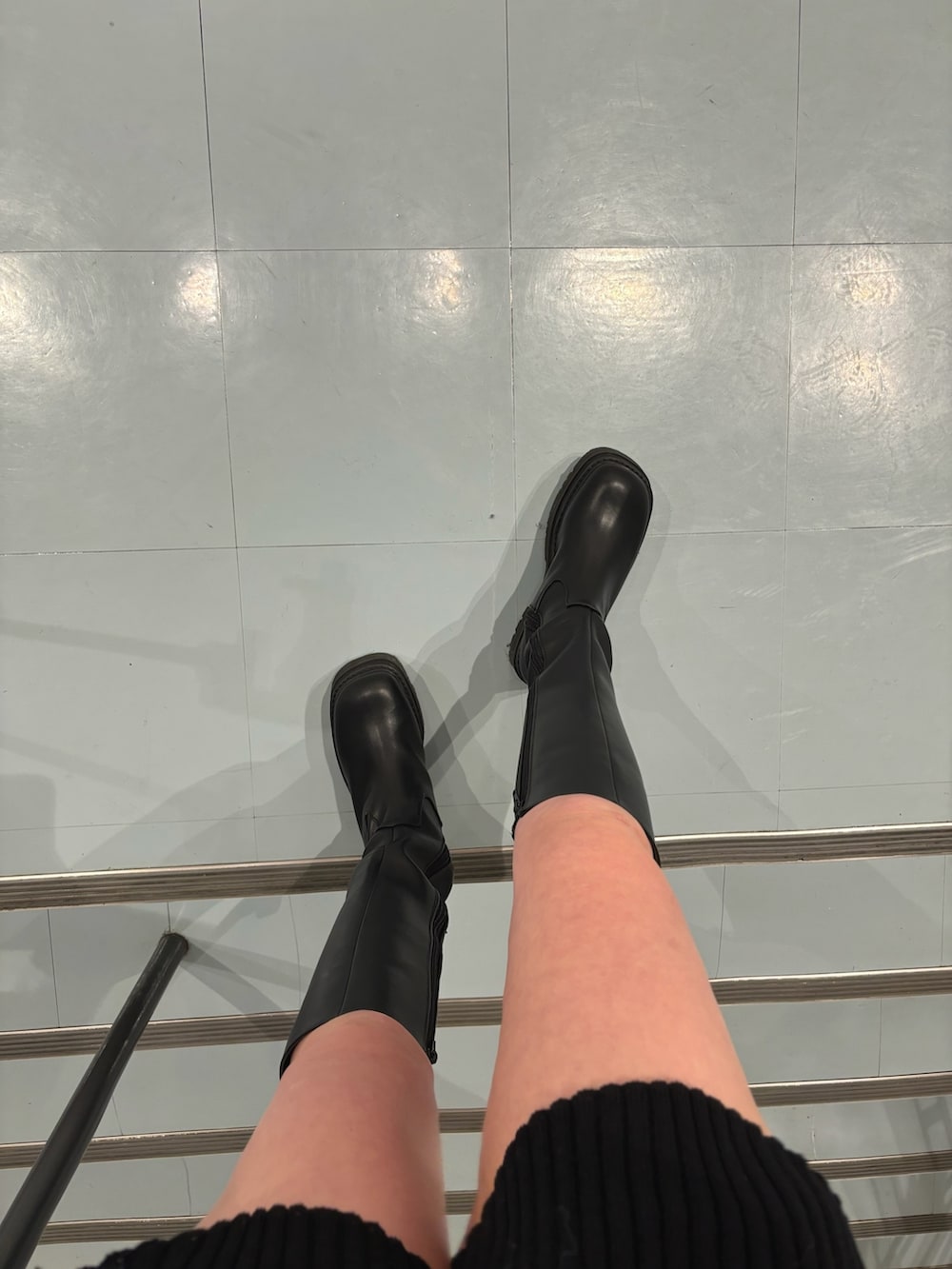 ブラック系のハンドバッグ、ブラック系のブルゾン、ブルー系のニット/セーターを着用したレディースの冬コーディネートの7枚目の写真