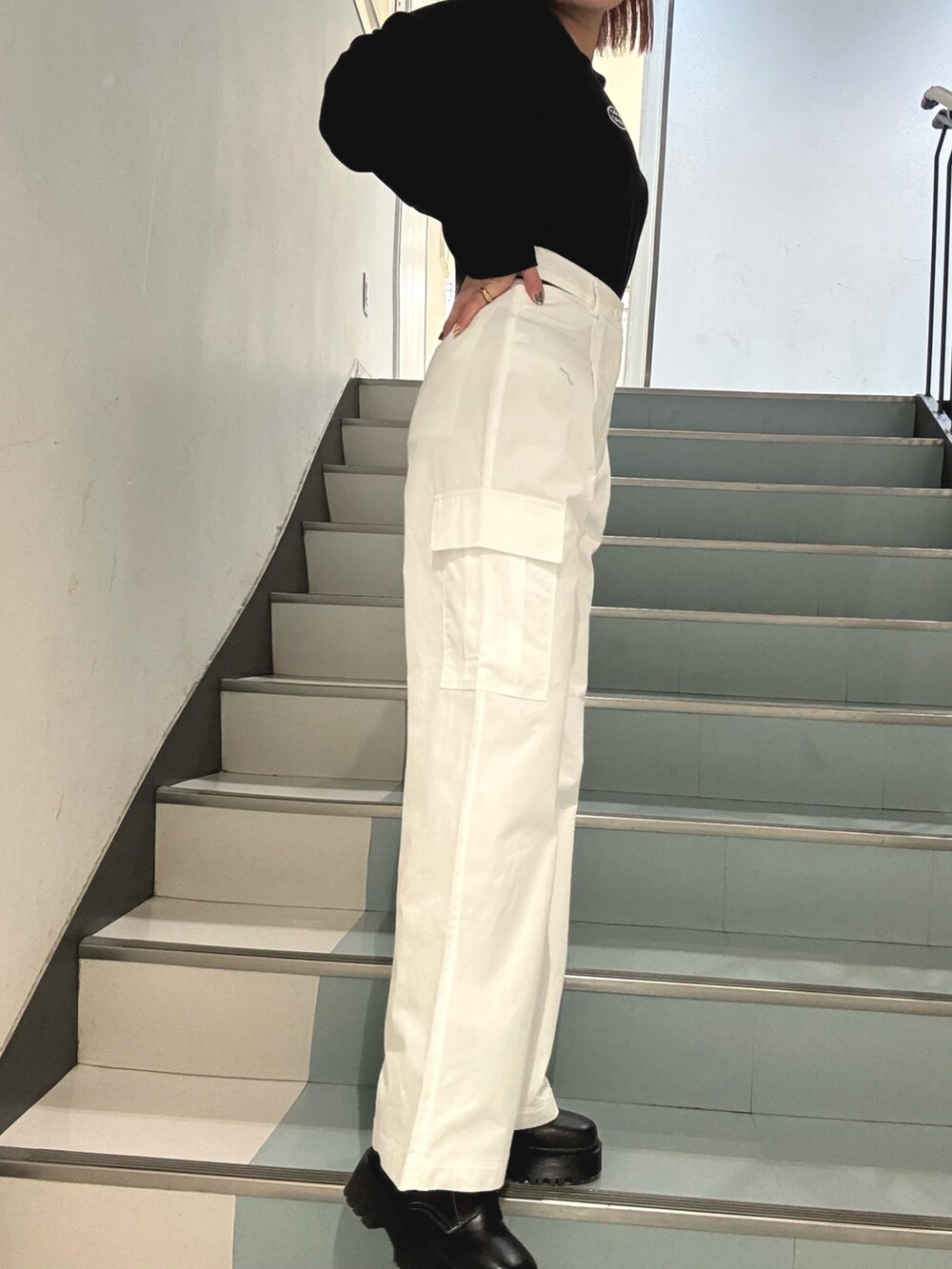 ブラック系のブーツ、ホワイト系のカーゴパンツ、ブラック系のTシャツ/カットソーを着用したレディースの冬コーディネートの5枚目の写真