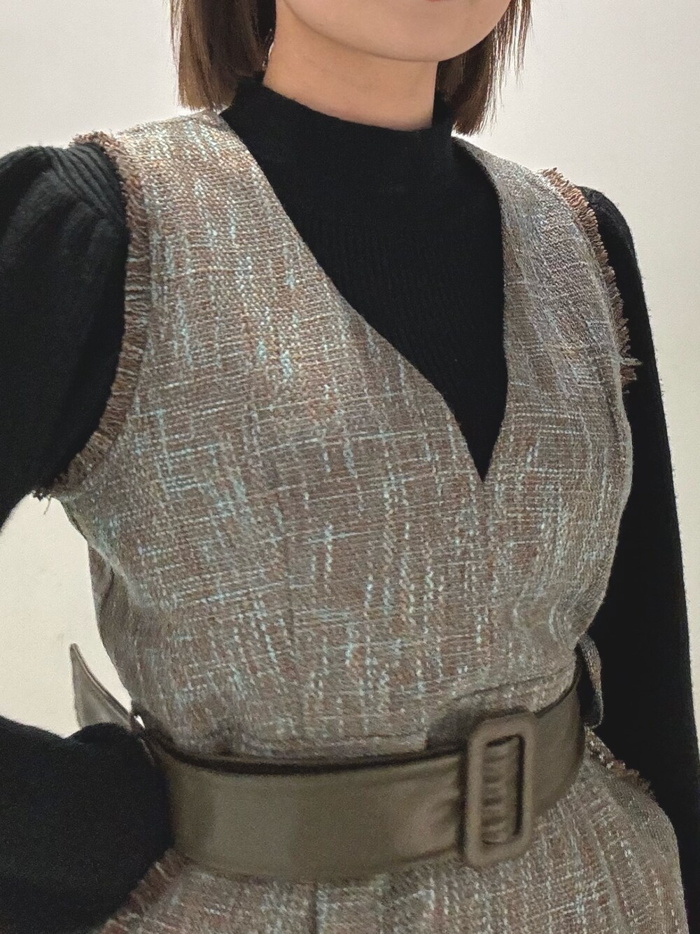 グレー系のダウンジャケット/コート、ブラック系のニット/セーター、グレー系のワンピースを着用したレディースの冬コーディネートの6枚目の写真