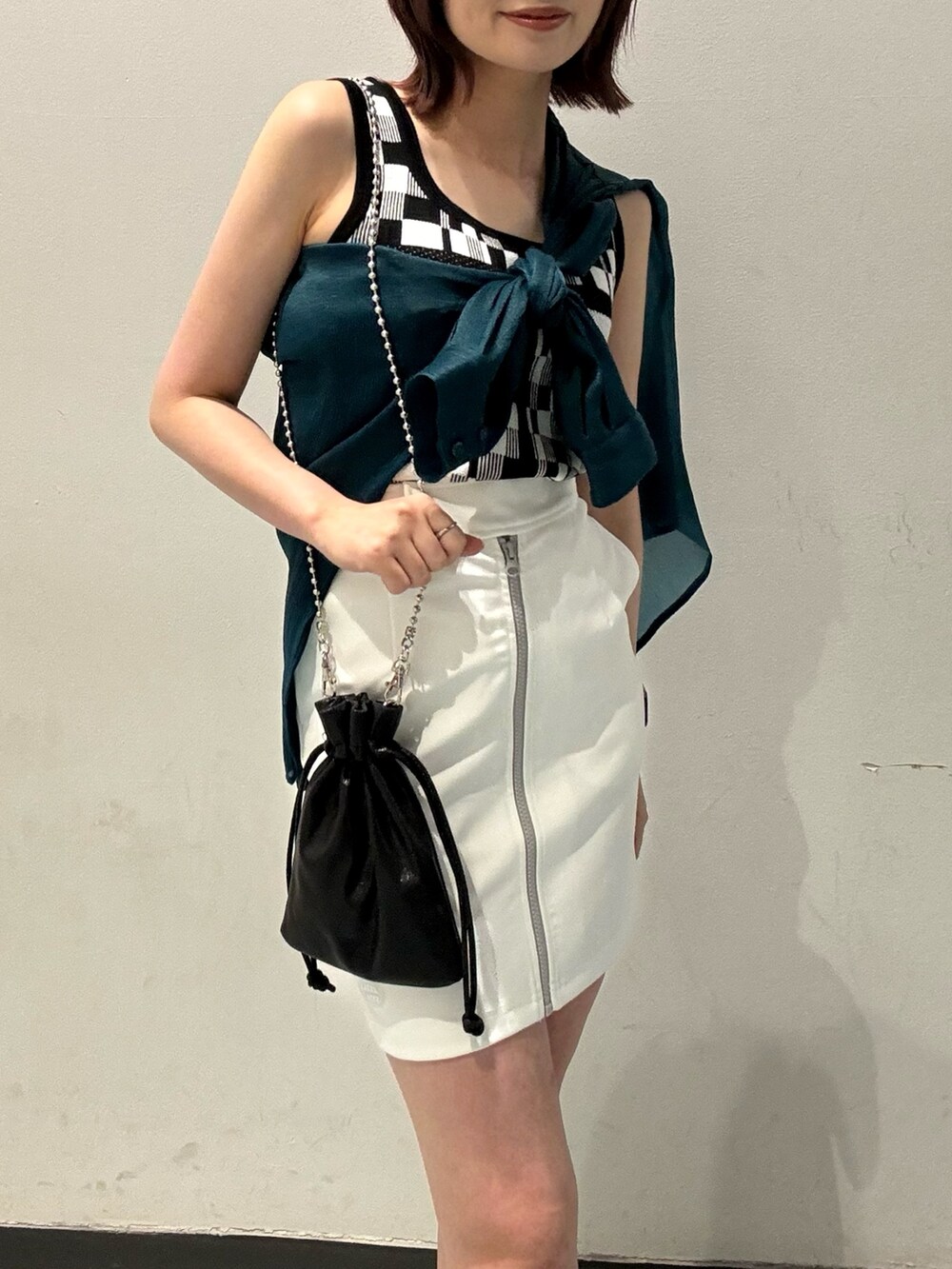 ブラック系のブーツ、ホワイト系のスカート、グリーン系のシャツ/ブラウスを着用したレディースの春コーディネートの5枚目の写真