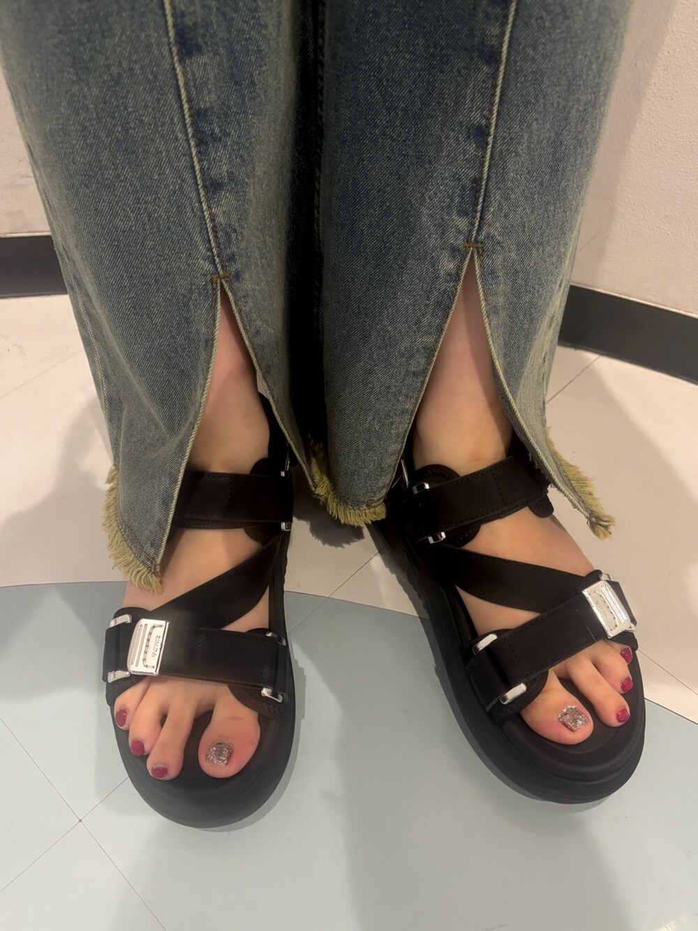 ブラック系のシャツ/ブラウス、ブルー系のデニムパンツ、ブラック系のサンダルを着用したレディースの夏コーディネートの7枚目の写真