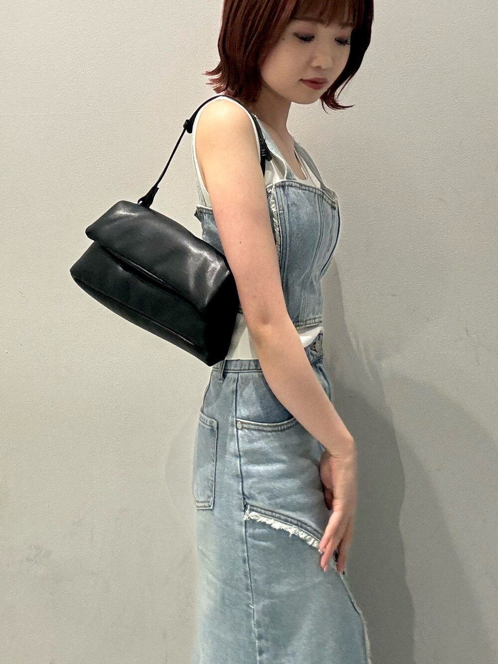 ブラック系のハンドバッグ、ブラック系のブーツ、ブルー系のシャツ/ブラウスを着用したレディースの夏コーディネートの5枚目の写真