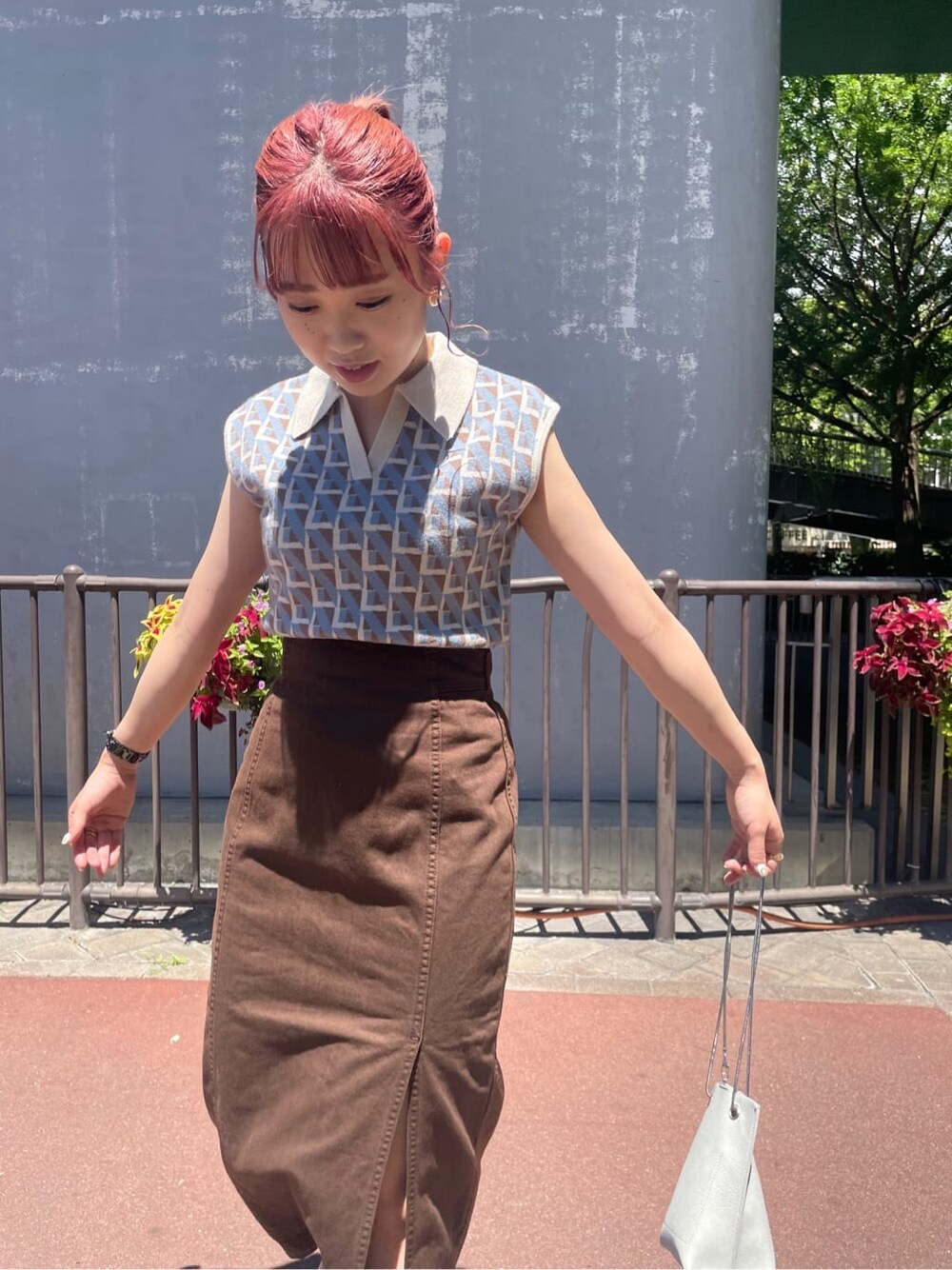 ホワイト系のショルダーバッグ、ブラウン系のブルゾン、ブラウン系のスカートを着用したレディースの夏コーディネートの3枚目の写真