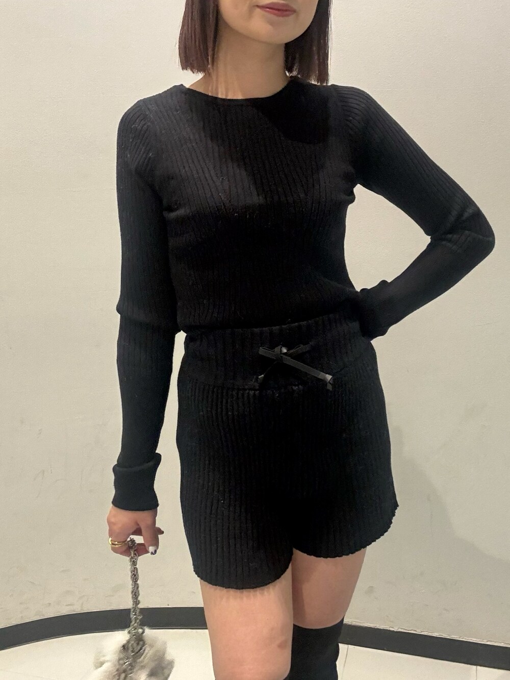 ブラック系のニット/セーター、ブラック系のその他パンツ、グレー系のムートンコートを着用したレディースの秋コーディネートの4枚目の写真