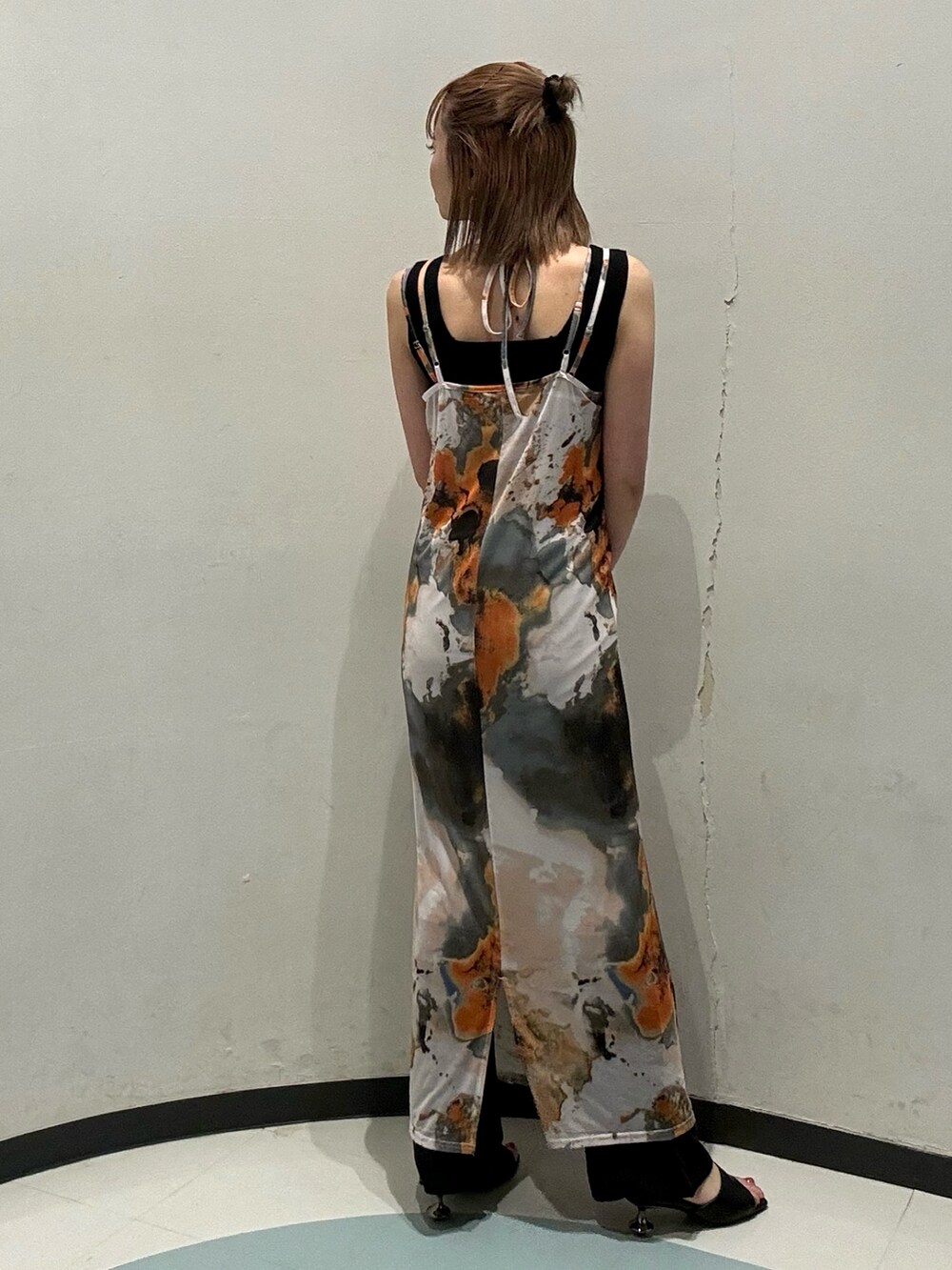 オレンジ系のショルダーバッグ、ブラック系のニット/セーター、オレンジ系のワンピースを着用したレディースの夏コーディネートの3枚目の写真