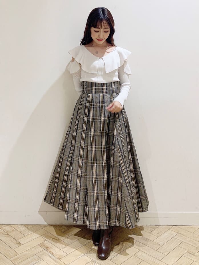 ベージュ系のスカート、ホワイト系のニット/セーター、ベージュ系のスカートを着用したレディースの秋コーディネートの2枚目の写真