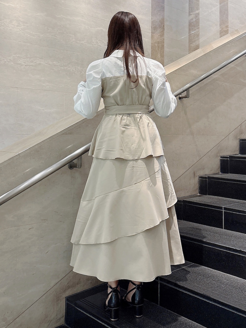 ベージュ系のワンピース、ブラック系のサンダルを着用したレディースの冬コーディネートの4枚目の写真