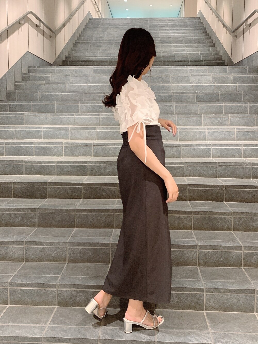 ブラウン系のスカート、シルバー系のパンプス、ホワイト系のTシャツ/カットソーを着用したレディースの夏コーディネートの5枚目の写真