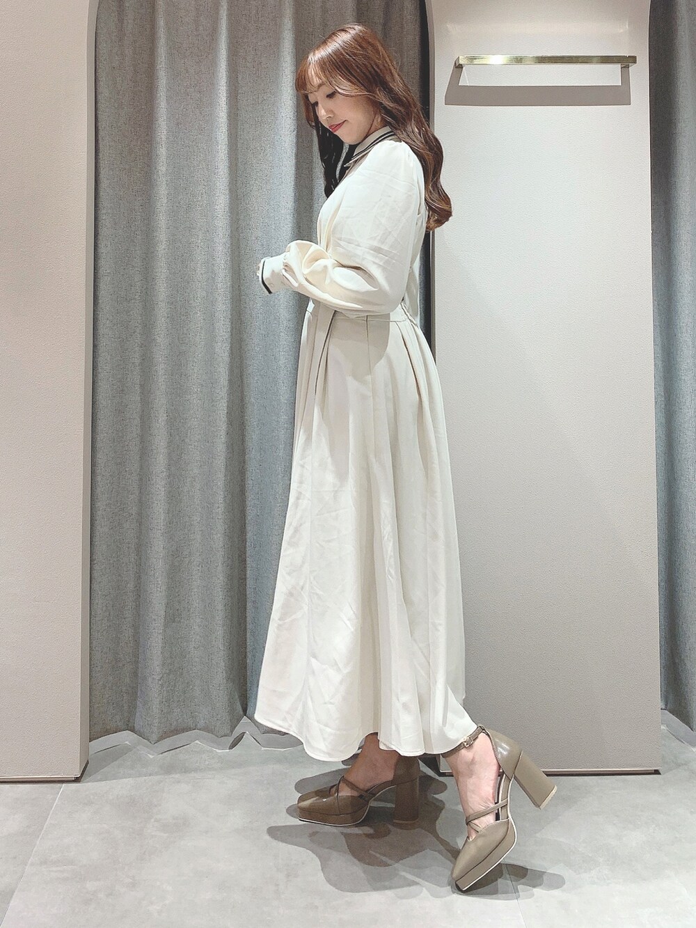 ホワイト系のワンピース、ベージュ系のパンプスを着用したレディースの秋コーディネートの5枚目の写真