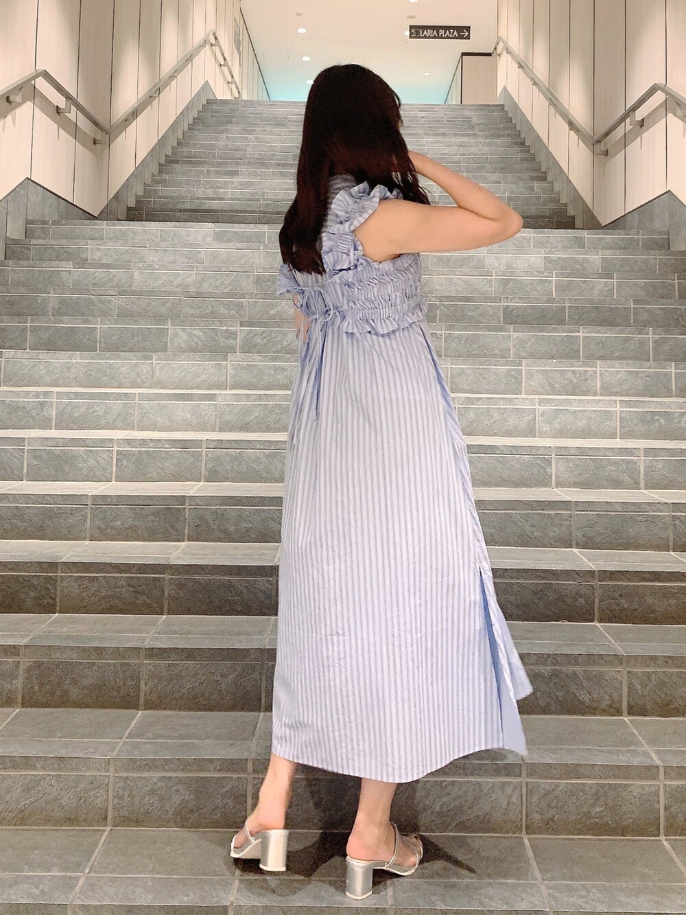 シルバー系のパンプス、ブルー系のシャツワンピースを着用したレディースの夏コーディネートの3枚目の写真