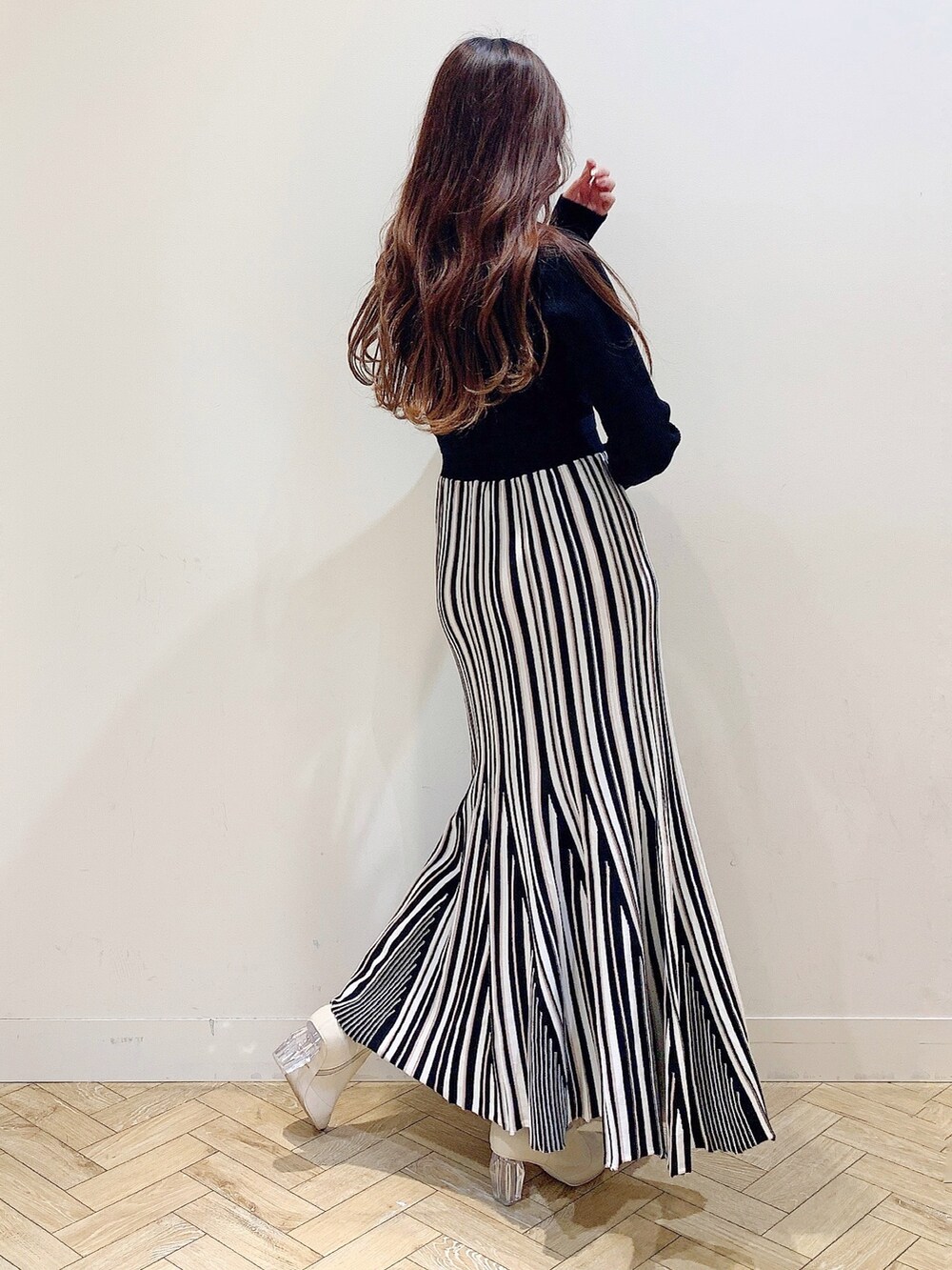 ブラック系のワンピース、ブラック系のダウンジャケット/コート、ホワイト系のブーツを着用したレディースの冬コーディネートの5枚目の写真