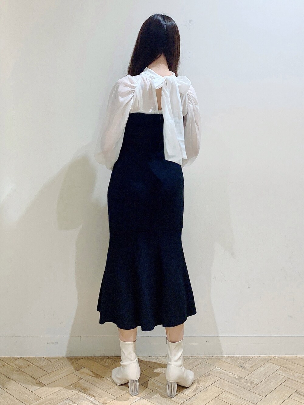 ブラック系のワンピース、ホワイト系のブーツを着用したレディースの冬コーディネートの6枚目の写真