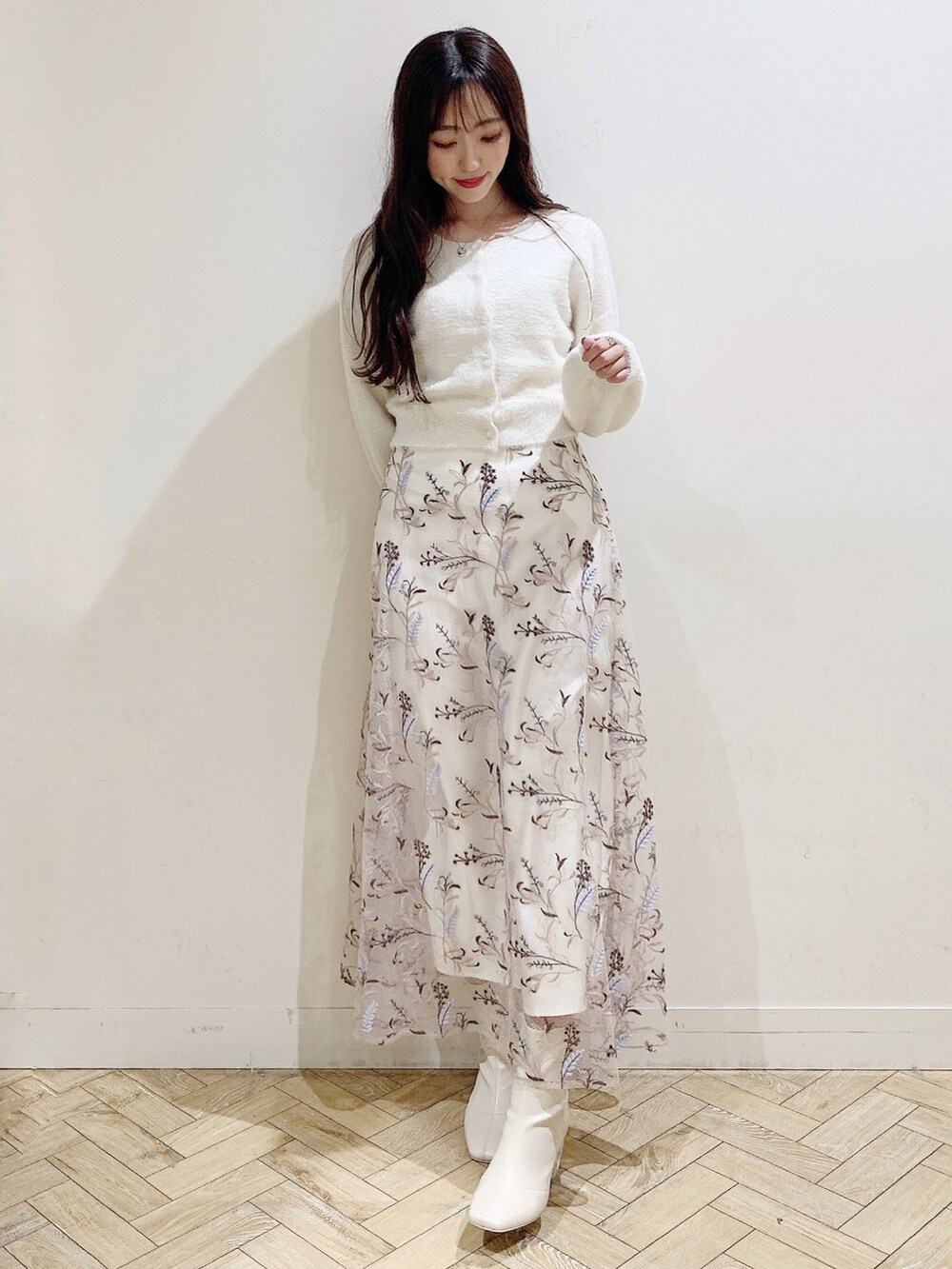 ピンク系のスカート、ホワイト系のカーディガン/ボレロ、ホワイト系のブーツを着用したレディースの秋コーディネートの2枚目の写真