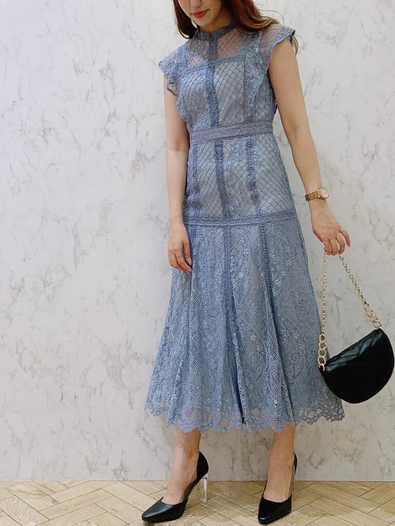 ブルー系のドレス、ブラック系のパンプス、ブラック系のハンドバッグを着用したレディースの夏コーディネートの4枚目の写真