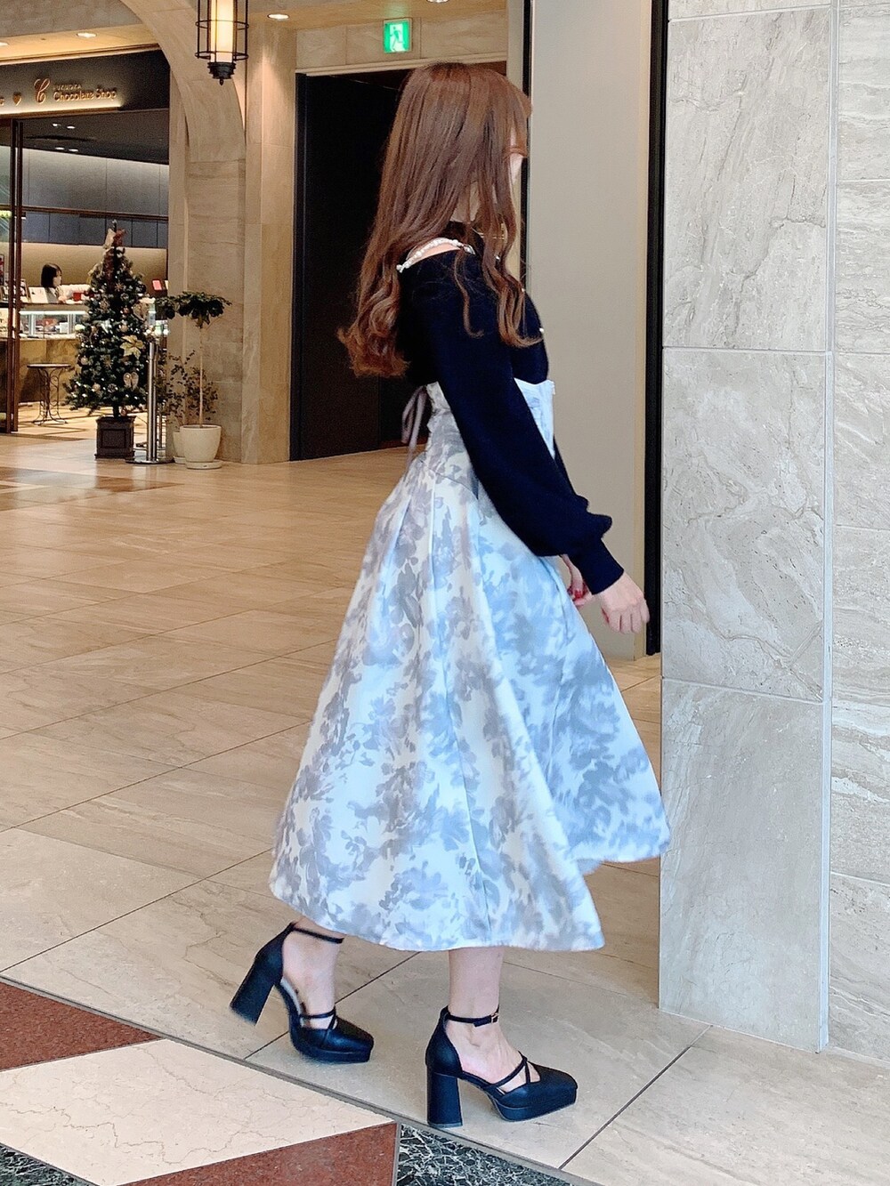 ホワイト系のスカート、ブラック系のニット/セーター、ブラック系のパンプスを着用したレディースの秋コーディネートの4枚目の写真