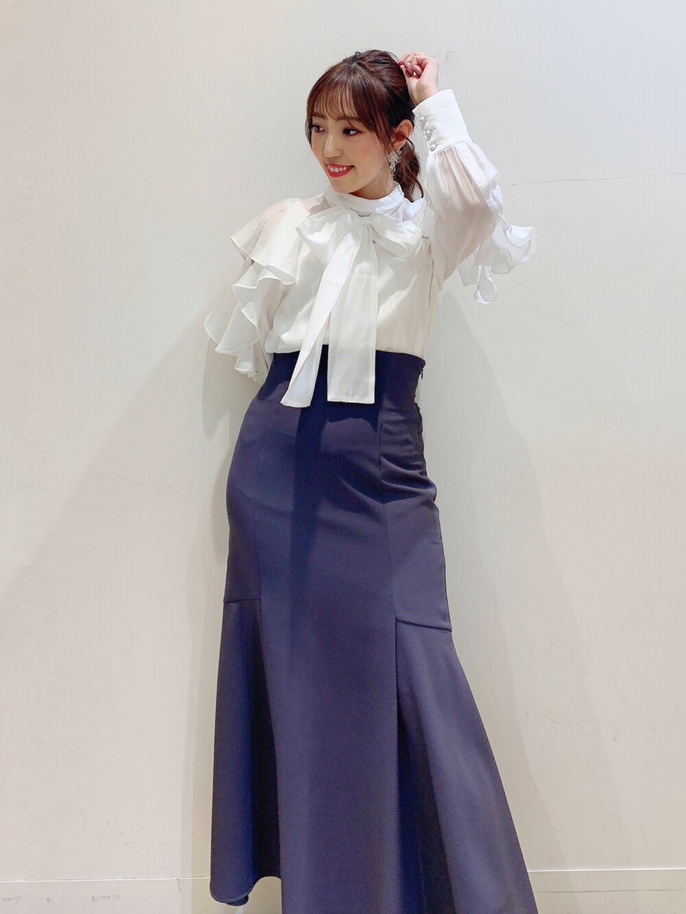 ホワイト系のシャツ/ブラウス、グレー系のスカート、ブルー系のハンドバッグを着用したレディースの冬コーディネートの7枚目の写真