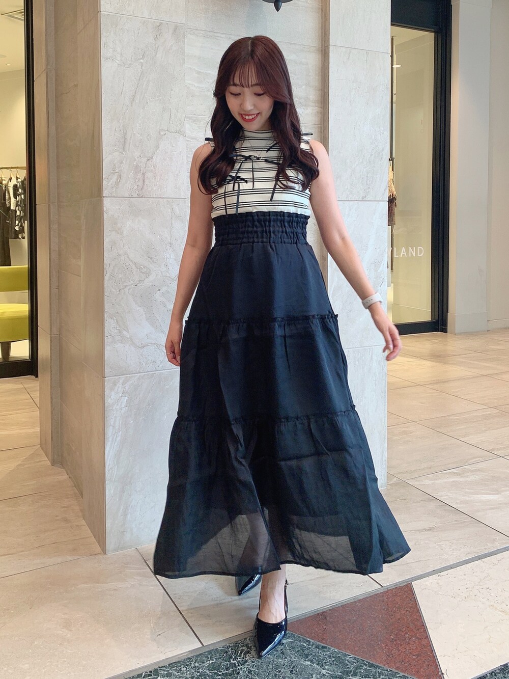 ブラック系のパンプス、ブラック系のワンピースを着用したレディースの夏コーディネートの4枚目の写真